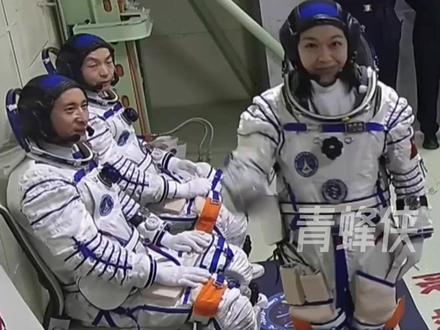 神二十三航天员进入飞船返回舱 黎家盈进舱前展示手臂上国旗并比心