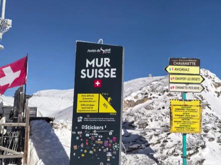 瑞士墙雪道(Mur Suisse)位于太阳门滑雪区的法瑞边境上,从Avoriaz 雪场坐Stade吊椅缆车后向西滑下一条蓝道往瑞士方向,再换Chavanette 拖牵或Choucas吊椅到山顶后向西滑行即可看见瑞士墙的大标牌。瑞士墙雪道据称是欧洲最难雪道,其平均坡度超过76%,最大90%,雪道上布满了巨大的“蘑菇包”,长达1000米,雪道也常因雪崩或冰面危险而关闭,因此被许多滑雪者称为“黑道中的黑道”。雪道顶端海拔超过2000米,对面是风景壮丽的锯齿峰。你可以滑到道边俯视雪道,如果胆怯了,可以坐旁边的吊椅下去观光,也可以去旁边的酒吧喝杯酒壮壮胆,就可以滑下去探究一下是不是最黑的道了😱