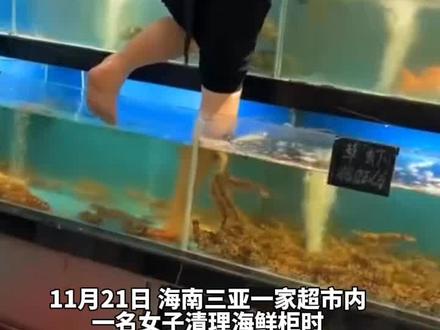 超市内女子赤脚站水缸里清理海鲜柜
