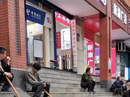 棒棒军肩上扛着一米长的竹棒,棒子上系着两根青色的尼龙绳沿街游荡揽活,他们来自农村,是重庆街头的临时搬运工