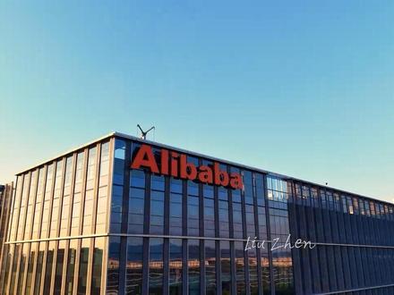 阿里巴巴西溪园区(淘宝城)是阿里巴巴集团全球总部所在地,位于杭州市余杭区文一西路969号,地处未来科技城核心区域。园区总规划占地26万平方米,总建筑面积超200万平方米,由日本建筑大师隈研吾设计,融合现代科技与江南水乡风格,形成“城市森林”生态布局。目前园区可容纳约1.8万名员工,涵盖淘宝、天猫、阿里云、蚂蚁集团等核心业务板块,同时配备健身房、超市、派出所等社区化设施,被誉为“企业中的小城”。
作为全球数字经济标杆,园区不仅是技术创新高地——拥有智能办公系统、“减碳大脑”等前沿科技应用,还通过LEED铂金级认证成为中国最大绿色办公社区。2024年新启用的全球总部以笑脸logo为标志性设计,象征阿里扎根杭州的初心。2025年,五期项目预计年底全面建成,届时将新增98万平方米空间,可容纳6万名员工,并通过海绵城市、雨水回收等技术进一步提升可持续发展能力。
近年来,园区持续深化与余杭区的战略合作,在智能物联、高端制造等领域协同发展。例如,2025年6月18日,阿里巴巴国际站将在园区举办外贸峰会,聚焦海外市场趋势与供应链创新。这里不仅是阿里人“快乐工作”的家园,更以开放姿态成为全球科技创新与文化交流的重要窗口。#杭州 #余杭 #阿里巴巴 #未来科技城 #马云