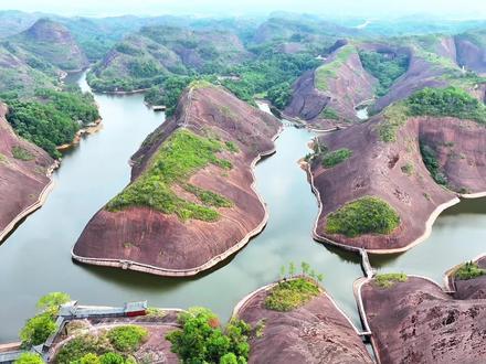 弋阳龙门湖水利风景区具有独特的魅力,以下是其详细介绍:
1. 基本概况:
• 地理位置:位于江西省弋阳县南岩镇龙门社区,周边有叶坝村、宝峰村、南岩村等,交通便利,物产丰富。
• 形成由来:龙门湖原为小型水库,于1958 年建成,总库容 195 万立方米,集水面积 3.5 平方公里。因有山体蜿蜒盘旋于水面,从上空看像一条巨龙卧在水中,故而得名。
2. 景区特色:
• 独特地貌景观:处于一片丹霞地貌中,流水潺潺被崇山峻岭间隔,自然形成多个大小湖泊。湖水沿着山坳漫漫延伸,呈现出“U”型发展态势。从空中俯视,整个龙门湖犹如一巨大的海珊瑚礁,礁林丛生,枝节繁多。四周碧顶丹崖,红岩绿水,相互映衬,景色壮美。
• 湖体形态优美:龙门湖的特点不在于大,而在于曲、在于秀、在于清、在于美。细细算来有 99 道弯,山骨在凸处盘绕,仿佛一条巨龙潜伏在红岩山坳,微风掠过,红石与绿水轻轻叩吻。
• 天然奇景众多:在湖的左侧尽头,清澈的湖底有六眼圆形池,池的大小不等,大的直径有两米,小的直径只有一米左右,洞很圆,仿佛神工精雕细琢而成,六眼圆洞均匀分布,从清清的水面上一眼可以望到底,其状奇巧至极,妙不可言。
3. 周边景点:
• 世界最大卧佛:龙门湖东侧有一天然形成的卧佛,长 416 米,高 68 米,为世界第一大卧佛。其底部由山石骨托起形成的龙门石拱状,犹如卧佛的颈部,头和身子空出地面浑然天成,从远处看,山是一尊佛,佛是一座山,让人惊叹大自然的神奇造化。
• 双岩古寺:在湖的右侧尽头是双岩古寺,茂林修竹,环境清幽,古刹森森。该寺依山就势,沿崖而建,浑然天成,以前也叫天成寺。
4. 景区地位:是一处集丹霞地貌、佛教文化、观光休闲、朝佛养生于一体的旅游胜地,是国家 4A 级旅游景区,2016 年被列入第十六批国家水利风景区。#弋阳龙门湖景区 #弋阳龟峰景区 #弋阳卧佛 #弋阳同城