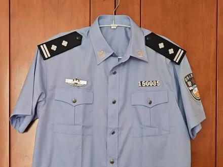 这是一款99式初期过渡款夏季半袖交警警服,以退役。该款警服缀金属胸标和警号(铁标),警衔面板平直,,肩扣是螺丝固定。2005年改款后,此款警服退役。改款后的服装夏半袖为夹克服,胸牌和警号取消改为魔术贴款,肩扣改为弹簧式卡扣,警衔也在2012年改为弧形板面。