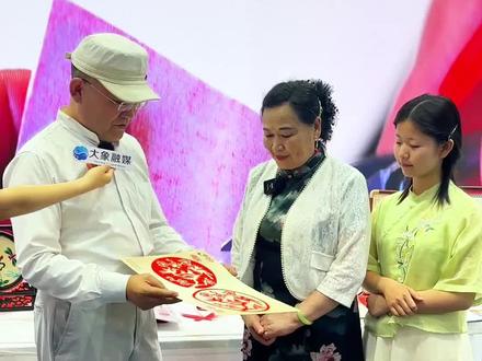 在第22届深圳文博会河南馆内,河南省非物质文化遗产剪纸代表性传承人“一剪成”胡明与孙女刘洛汐现场同题表演“一剪成”剪纸绝技,引得观众纷纷驻足观赏。来自深圳大学的王教授被“一剪成”技艺折服,希望剪纸技艺能进校园,让更多的孩子能了解中国的传统文化#深圳文博会河南馆#剪纸#非物质文化遗产
