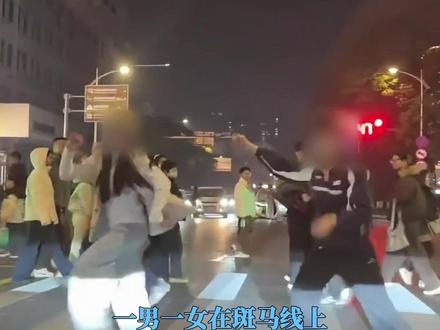 一男一女趁车辆等红灯时,在斑马线上对着车辆跳舞;有网友担忧:该行为存在交通安全隐患;交警回应:会加强相关路段管理