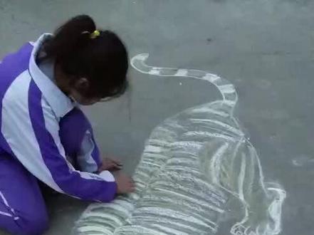 孩子放学后在地上用粉笔画老虎🐯