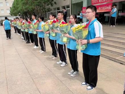 高一高二学生向高三学长学姐献花送上深深的祝福