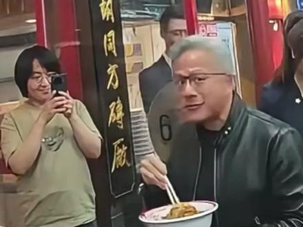 边吃边夸!黄仁勋在店门口端着碗吃炸酱面,还用中文和周围人互动