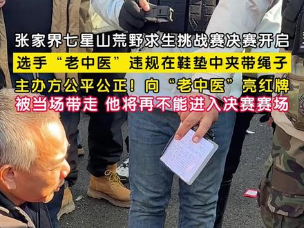 11月24日,湖南张家界。#七星山荒野求生挑战赛决赛 开启,选手“老中医”违规在鞋垫中夹带绳子。主办方公平公正!向“老中医”亮红牌,安全员将他当场带走,按照比赛规则,他将再不能进入决赛赛场。#荒野求生决赛老中医夹带绳子被红牌罚下 (记者 赵荆威)