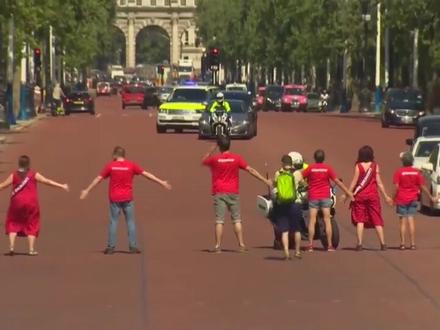 气候变化抗议者冲上街道组成人肉链条,阻拦英国新首相约翰逊觐见女王的车队。