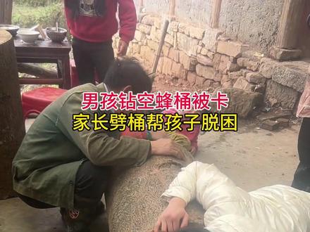 男孩钻空蜂桶被卡,家长劈桶帮孩子脱困