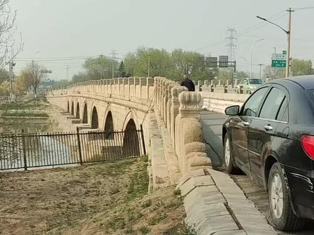 朝宗桥 朝宗桥,又称沙河北大桥,位于北京市昌平区沙河镇昌平路141号,与安济桥相对,始建于明正统十三年(1448年),是京城北部最大的连拱石桥,与卢沟桥、永通桥、马驹桥、安济桥合称为“拱卫京师五大桥梁”。朝宗桥全部用花岗石砌筑而成,全长130米,宽13.3米,中孔高7.5米,七孔连拱结构,中孔最大,两侧桥孔依次减小。中孔拱券券脸石正中雕刻有镇水兽。桥上两侧有实心护栏,上雕海棠纹饰,石栏柱53对,桥头云堆抱鼓石。桥下两端建有石砌驳岸,上有伏卧镇水兽。朝宗桥是通往京北的咽喉,北控居庸关、白羊口,东扼古北口,同时也是明朝帝后、大臣谒陵北巡的必经之路,具有重要的政治、军事和经济地位。
明正统十三年(1448年),明英宗诏命工部右侍郎王永寿拆掉南北沙河上的木桥建石桥,于南北沙河上各营建石桥一座,南曰安济,北曰朝宗。明景泰七年(1456年),朝宗桥修缮。明嘉靖十五年(1536年),朝宗桥修缮。明嘉靖十七年(1538年),朝宗桥修缮。明万历三年(1575年),朝宗桥修缮。明万历四年(1576年),朝宗桥部分结构被水冲断,修缮后将石拱碹改为砖拱碹。
民国四年(1915年),朝宗桥修缮。
民国二十六年(1937年),侵华日军进攻北平,朝宗桥遭炮轰,桥体留有痕迹。
1953年,朝宗桥修缮,并在条石桥面上铺筑沥青路面。
20世纪80年代,为防止机动车撞损朝宗桥桥栏的事故再次发生,昌平公路分局在行车道两侧设置260米长的隔离墩。
1989年,朝宗桥修缮,并进行保护性加固,在砖拱碹的外面加喷混凝土层。
2022年,北京市昌平区文旅局对朝宗桥进行检查评估,研究显示朝宗桥总体风险级别很低、总体保护情况较好。