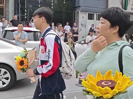 6月7日,高考首日,在石家庄市一中考点外,刚到7点钟,一位考生母亲王女士手捧手工制花向日葵,目光紧盯着来集中送考的大巴车。(长城网·冀云客户端 张艺萌 智建勋 任英飒)#高考 #高考加油