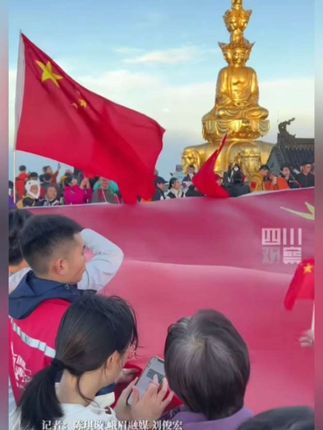 10月1日,四川峨眉山。云海之上第一缕阳光照耀大地,游客手拉国旗高声歌唱 《我和我的祖国》(四川观察)