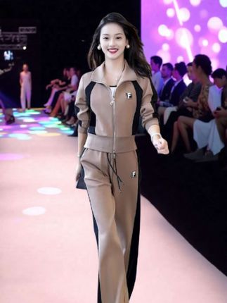 这是一套运动风套装,整体为卡其色,衣身侧边有黑色拼接设计,增添时尚感。上衣是立领拉链款式,胸前有带字母“F”的标志;下装是阔腿长裤,同样有字母“F”标志,搭配白色休闲鞋,简约又具潮流感,适合日常休闲或轻运动场合 ! 休闲运动服套装≠卫衣阔腿裤两件套≠时髦穿搭≠毫不费力地打开初秋穿搭≠好看的套装