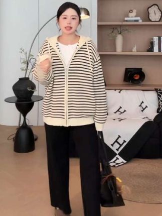 【知葵微胖定制】条纹手册—早秋韩系慵懒条纹连帽毛衣外套 当早秋的风带了凉意,总需要一件能裹住所有松弛感的外套——这件韩系条纹连帽毛衣,就是为「不费力的时髦」而生。宽宽松松的大版型,藏肉又显肩线,搭leggings露脚踝是元气少女,配直筒裤卷边穿是慵懒学姐,怎么穿都没有束缚感。经典黑白条纹不挑肤色,自带韩剧女主的滤镜感,随便搭个帆布包就很有腔调。厚款针织面料软乎乎的,贴身穿不扎肤,早秋单穿抗风,深秋叠在大衣里当内搭也不臃肿。连帽设计比普通外套多了份随性,拉上抽绳是可爱的软妹,放下帽檐又带点不经意的酷,一件承包你早秋所有日常场景。#大版外套 #大码毛衣外套