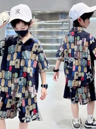 这款夏季中大童套装,将沙滩度假风与国潮元素巧妙融合。主体是一件宽松花衬衫,采用透气面料,上身清爽不闷热。印花以海浪、椰树为基底,点缀祥云、瑞兽等国风图案,色彩明快却不张扬,港风复古感十足。搭配同系列短裤,侧边撞色条纹设计增添活力,松紧腰头方便穿脱。整套造型可单穿度假,也能内搭T恤日常出行,轻松驾驭沙滩玩耍、逛街聚会等多种场景,让孩子在夏日里既时髦又舒适,尽显自在潮酷范儿。#夏季穿搭 #清凉一夏 #夏款上新 #面料柔软舒适 #潮酷男孩