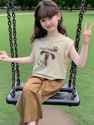 💫 夏日萌趣穿搭 | 网红爆款两件套💫, 海边草坪的阳光里,小女孩一身萌趣穿搭超吸睛✨ 浅米色小飞袖上衣,印着可爱小狗图案,面料柔软透气,像把夏日凉风穿在身上🍃 搭配同系列棕咖色阔腿裤,垂坠又轻薄,跑跑跳跳间满是灵动~, 这套网红洋气两件套,把“凉快”和“可爱”狠狠拿捏🧸 面料亲肤不闷汗,版型宽松无束缚,小朋友自在玩耍也能美美的~ 当下爆款,萌娃出街回头率爆表,宝妈们别错过给宝贝囤夏日靓衣呀💕, #儿童穿搭 #夏日爆款 #网红童装 #舒适洋气 #萌娃穿搭@DOU+上热门 @DOU+小助手