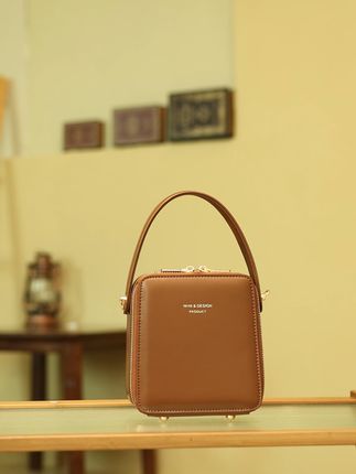 入秋第一件复古包,焦糖色牛皮竖款手提盒子包 #焦糖色包包 #竖款手提包 #牛皮包包 #盒子包包 早秋的风带着一丝凉意,也吹来了复古的气息,这款焦糖色牛皮竖款手提盒子包便是为早秋量身打造的复古神器。温暖的焦糖色与早秋的落叶、暖阳相映成趣,牛皮的质感在微凉天气里更显温润。竖款盒子造型自带复古腔调,手提在身,搭配针织开衫或风衣,仿佛从老电影里走出来的画面,让早秋的每一步都充满复古韵味。