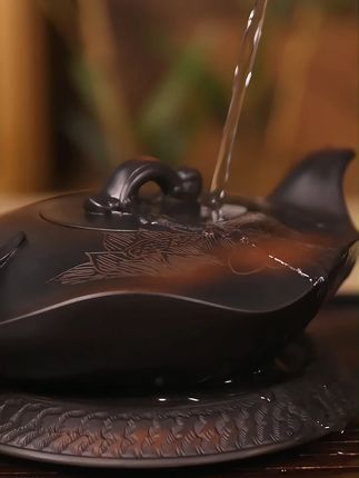 喝茶的人一定要有一把紫陶爱莲壶,一分浅一分扁,仿生荷叶器型,壶身图案由匠人精工刻绘,一面一首爱莲说诗词,一面是荷花在水中绽放,倒水时还会发出清脆的鸟鸣声,350毫升黄金容量#紫陶壶#匠心制作#器物之美