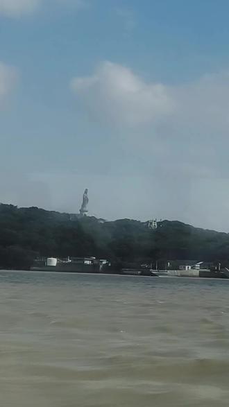 普陀山的海风裹着潮声,托起三十三米的慈悲。观音立在莲花台,眼眸垂处,众生皆安——她是海天之间的温柔,是千万人心中的信仰,也是岁月里最静的守护。站在观音像前,突然懂了‘慈悲’的模样:不是高高在上的俯视,是低眉时的悲悯,是掌心托着的净瓶,把所有苦都酿成了甘露。风动,云动,心却静了。海是蓝的,天是蓝的,观音的衣袂也是蓝的。浪打礁石的声音里,她站成了永恒——原来最动人的信仰,从来不是宏大的承诺,而是‘我在’的笃定。愿观音垂怜,予你平安喜乐,予我心有归处。所求不多,不过是家人安康,岁月从容;所念皆善,自有清风来相和。见观音,心自安。海天之间,慈悲永恒。三十三米的温柔,接住人间千万愿。