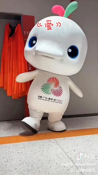 一声“大湾鸡”,让第十五届全运会吉祥物火出圈。
“大湾鸡”不是鸡,官方名“喜洋洋”“乐融融”,原型是中华白海豚。然而,圆润的体型、粉白的配色,让人不禁联想到白切鸡、豉油鸡。鸡在粤菜中地位不凡,大湾区人民顺势赠其爱称“大湾鸡”。
热梗背后,有“湾区人”热爱生活的温度。作为商都、水脉交汇之地,大湾区自古孕育出灵活、开放、务实、幽默的民风。当地人习惯用市井语言拉近距离,用诙谐表达亲密。给吉祥物起个“鸡”名,就像给老友取个外号,既接地气,又饱含深情。轻松中,正是人民对生活的热爱与对本土文化的自信。
官方的包容,让“大湾鸡”焕发出新的生命力。尽管是一次设计和文化碰撞而产生的美丽误会,设计师刘平云却说:“民众发自内心的传播,比官方宣传更有生活气息。”全运会宣传语“活力大湾区,魅力新广圈全运会能够稳稳接住这波蓬勃的民间情感,得益于在疏导中激活创造、在欢笑中凝聚认同,由此超越体育赛事,成为一场全民共享的文化盛宴。
尽管被“指豚为鸡”,吉祥物的寓意却没有变。“大湾鸡”头顶的“三色浪花”,分别代表广东木棉红、香港紫荆紫、澳门莲花绿。如今,文化真正活在人群之中,体育融入市井烟火,“三地同心”的象征反而被更好地传达了。大湾区的同气连枝、美美与共,还将继续流转在街头巷尾的谈笑与热气里,越行越远,越浸越靓。