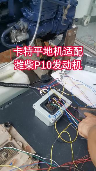 卡特平地机装潍柴P10发动机连接协议盒上发动机 这是卡特的平地机,换装了潍柴P10的发动机电脑板,现在来给它做一个测试。做好协议盒后,进行测试。这个是仪表,这个是变速箱电脑板,这个是协议盒,这个是原车上的一个线束。现在把这一条线插上,直接对插潍柴的发动机电脑板。这个是预留的一个OBD接口,插到诊断座上。这个是对应的线号,插到协议盒的插头上。这个协议盒其实就是插原车线束,原来插发动机电脑板的那个70P插头。那个插头就是原车电脑板的70P插头,线都已经插好。这个插头还有很多空插孔,空插孔被我定义成了协议盒的转接功能,用于潍柴发动机电脑板的针脚。把相应的针脚号插到我的插头的孔里面去就好了。因为现在我在测试,插到孔里面的话还要一根一根去拔,所以这里我就不做演示,我只是插到这个插头上的针脚上。