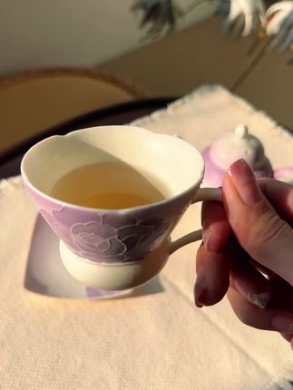 晨光里的瓷上浪漫,舌尖上的温柔仪式 杯身凝着揉碎的紫玫瑰,似将暮春的馥郁封入瓷釉,每一道花痕都带着手工勾勒的细腻,仿佛风过时花瓣轻颤的弧度。糯米釉质温润如乳,指尖触到的瞬间,便卸去了清晨的匆忙。 当滚烫的咖啡注入,杯壁光影流转间,玫瑰纹样似被唤醒,连带着咖啡香都染上了几分雅致。无论是独酌时的静谧,还是与友人分享的惬意,这只杯子都能让寻常的咖啡时光,变成一场与浪漫撞个满怀的温柔仪式。#茶生活 #下午茶 #茶器之美 #喝茶那点事 #高端茶器