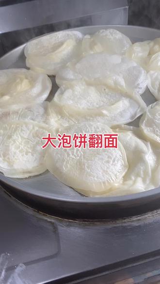 #美食 大泡饼教程;高筋面粉500克,糖8克盐6克,温水300克,面和均匀下90克剂子,揉成椭圆形盖上保鲜膜醒一小时,把醒好的剂子擀薄抻长盘起,空气裹里面就起泡了,锅温220度,烙至两面金黄即可。
