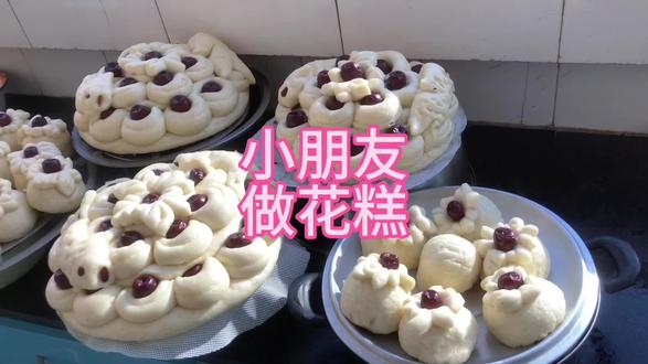 小朋友做花糕 先将发好的面拿一块,做成饼,再拿一块面搓条切成段,包上枣,围一卷放在饼上:再做一层,上面做一个花'中间再放个枣,再做个鱼放在两边,上笼蒸30分钟,漂亮的花糕就好了#真材实料才能做出好味道 #动手自己做美食 #味道好极了你们想吃吗