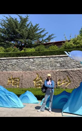 #跟着丫妈去旅行。烟台之烟台山。烟台山是烟台市的得名之处。烟台古称芝罘,相传是秦始皇四次寻找长生不老药而无果的地方,为此秦始皇命名为“芝罘”,芝就是灵芝,罘是秦始皇起的字,四不,就是四次都没成功。
明朝时,为抵御倭寇,在山上设熨斗墩,烽火台,发现敌情,昼则升烟,夜则举火,以为警报,简称烟台。此山因此而得名“烟台山”。清光绪三十一年(1905年),烟台山建起灯塔,命名为“烟台山灯塔”,这也是烟台的由来。
沿着烟台山拾阶而上,鲜花簇拥,绿树成阴,山不高,不一会儿就来到了红顶白衣的烟台山灯塔前,这是这座山的标志,也是烟台的标志,是山的最高处。看到可以登塔参观,我和老爸兴奋不已,立马买了票乘梯直达塔顶,错落有致,各式各样的红色屋顶围绕一望无际碧蓝的大海就在脚下。塔顶的风有点大,就像当时的心情自由自在,大家都把帽子藏了起来,不然帽子就会像我们的心情一样,向无尽的海岸线放飞。
也许有了登塔的意外收获,让我们的烟台执行变得无比开心,以至于当我们一路欢愉来到山脚下,才想起我们竟然忘了在灯塔下与之最近距离的合影留念。😄