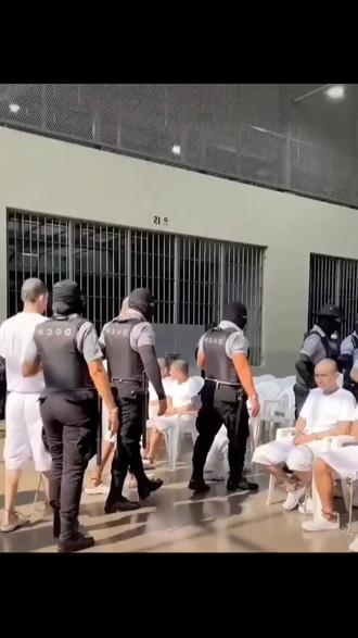 这些人所在的监狱是萨尔瓦多的CECOT(恐怖主义监禁中心),也被称为“超级监狱”,是世界上最大的监狱之一,专门关押MS-13、Barrio 18等暴力黑帮的成员。
• 这场景,是2026年4月的一次集体庭审:486名MS-13黑帮成员通过视频连线,在监狱内接受法院审判,他们被指控参与了超过47000起犯罪(包括近3万起谋杀案)。
~关于他们的眼神和气质
这些人长期混迹黑帮、经历暴力犯罪后留下的特征:
~他们中的很多人是MS-13的核心成员,长期以暴力、恐吓为生,眼神里带着狠戾、麻木,甚至是对死亡和惩罚的漠视。
~光头、统一的白色囚服、大面积纹身,加上脚镣手铐,都强化了这种“不好惹”的气场。
~但在萨尔瓦多政府的铁腕扫黑政策下,这些曾经在街头横行的黑帮头目,如今也只能在严密看管下接受审判,很多人将面临数十年甚至上百年的刑期。