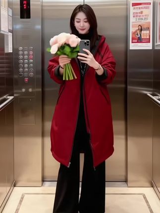 #创作灵感 暮色漫过落地窗时,她指尖轻触模特身上的酒红风衣——同色系的衣摆在她肩头坠出温柔的弧度,像将傍晚的绯色揉进了布料里。  窗外摩天轮的光渐次亮起,裹着雪意的风掠过玻璃,室内蓝玫瑰的冷香与衣料的软滑撞个满怀。她偏头时,发丝蹭过领口的黑绒,笑意漫在眼底,像把冬夜的暖都藏进了这一身舒展的红。  衣摆垂落的褶皱、鞋尖轻叩地面的细响,都裹在这方空间里,成了日常里轻缓的诗。连投影里复刻的身影,都晕着同频的温柔,像把此刻的松弛,酿成了可以触摸的质感#秋冬新款 #冬日穿搭#减龄气质 #厚外套给的安全感