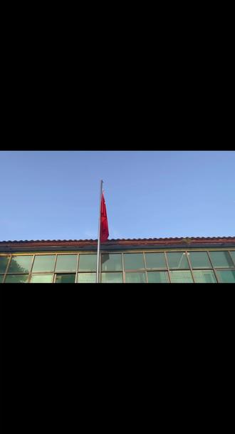 听到歌声,静止的五星红旗居然飘扬起来。