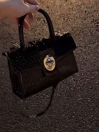 姐妹们快来看看这只超适合早秋的小包包,它是这种鳄鱼纹的漆皮,看起来就很有光泽感,而且摸起来的手感也非常的细腻舒服,整个包身都是这种硬挺的,不会轻易变形,里面的空间也很大,平时放个手机、化妆品啥的都没问题,关键它还很百搭,衣服随便一搭都很好看。