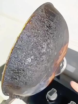 家里锅底黑成这样变这样的,快试试这款锅底除垢剂,套上手套,将除垢剂均匀的涂抹在锅底。