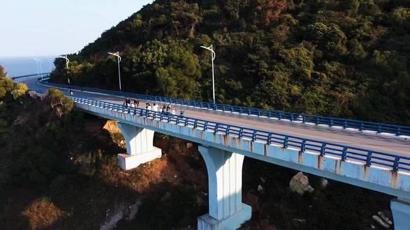 屿见闽南之漳州东山岛‖ 苏峰山环岛路 屿见闽南之漳州东山岛‖ 苏峰山环岛路
东山岛苏峰山:一半悬崖一半海的浪漫
在东山岛被苏峰山美到失语
274.3米的山顶藏着太多惊喜
三面临海的悬崖把蓝绿撞成一幅画
终于懂为什么叫"东山第一峰“了
明代江夏侯周德兴巡海时站在山顶
望着这山海奇观直接封神:
“这景比峨眉还绝,苏东坡见了得写十首诗!”
于是取了“苏”"字配"峰”,《东山县志》都记着呢。现在听着海浪声,总觉得真有诗仙的魂飘在风里
必冲!红蓝环岛路
坐在电瓶车上”天路”的瞬间
悟了什么叫"一半悬崖一半海”
红蓝大桥像彩虹缠在山腰间
停在观景台往下看一
金色沙滩镶着果冻蓝的海
远处渔船慢悠悠划过水面
再往东南望,那片海的尽头就是台湾。
来这儿才明白什么叫"山海浪漫”
风是甜的,海是蓝的
连空气里都飘着让人想发呆的魔力
来东山岛一定要留一天给苏峰山#自驾游风景 #无人机航拍